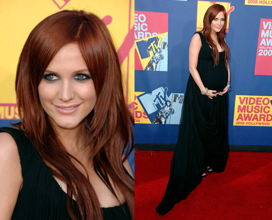 Her red hair and striking green eyes contrasts her black ensemble to 
