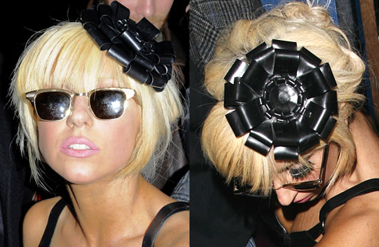  her blunt-cut fringed hairstyle accented with a shiny black fascinator.